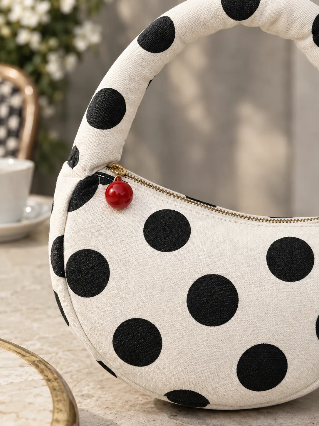 Half Moon Pouch Bag, close-up: the padded tube handle and red zip pull