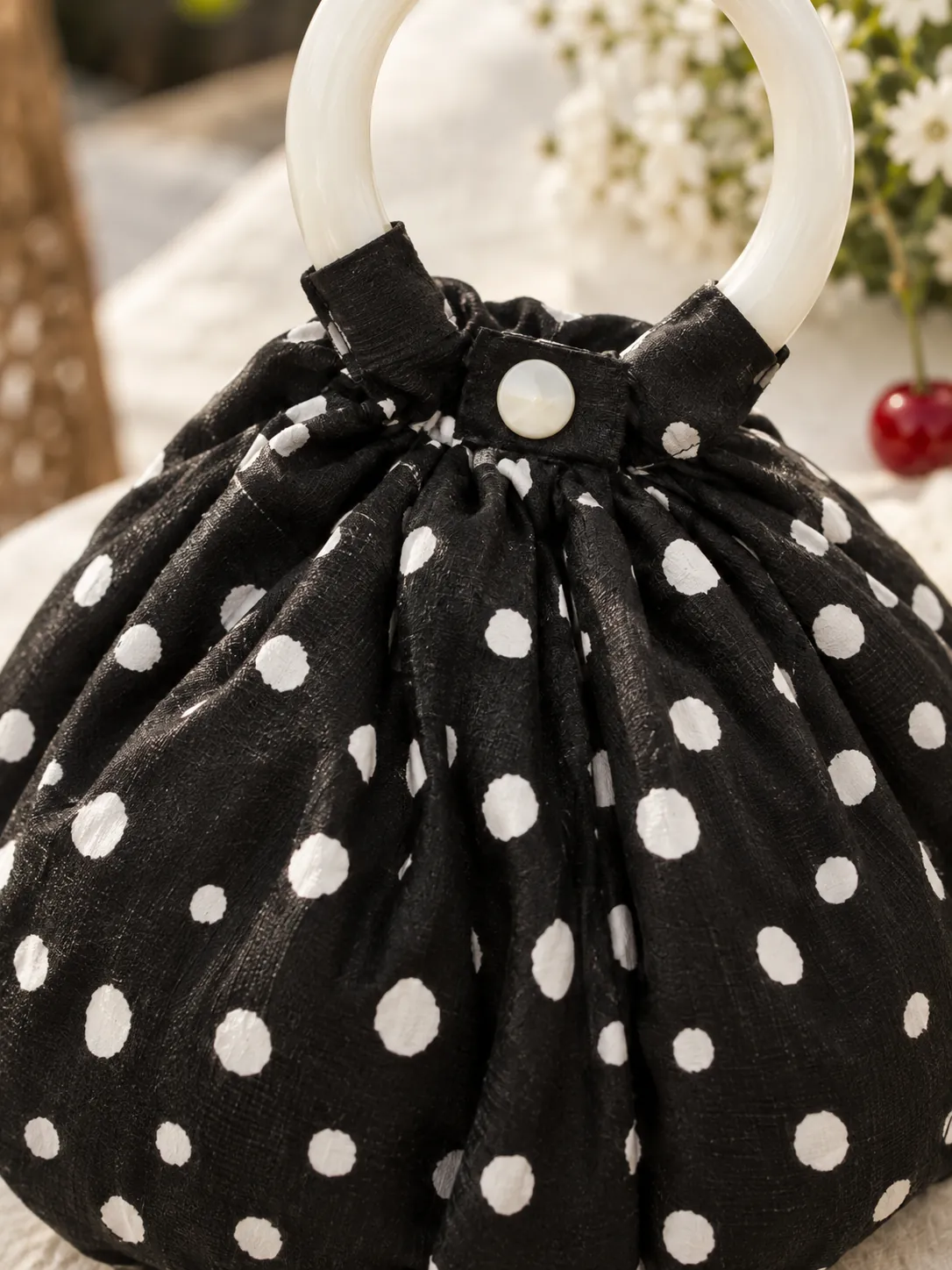Ruched Dumpling Bag, close-up: the gathered ruching and ring handle