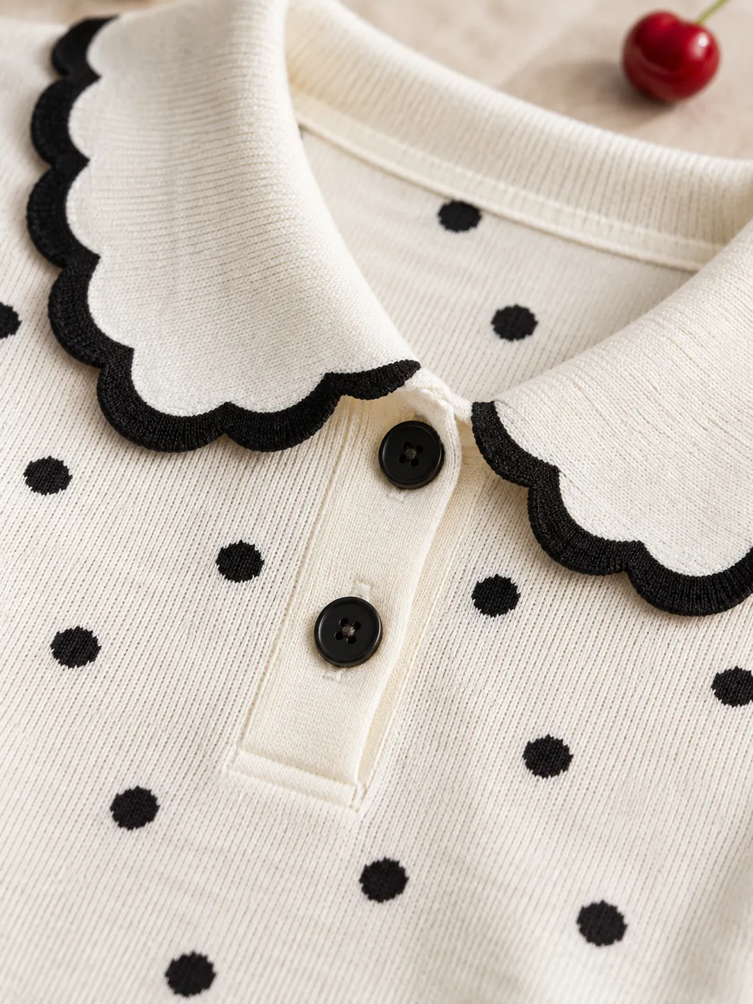 Scallop Trim Knit Polo, close-up: the scalloped black collar trim and knitted dots